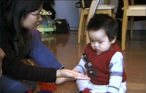 Mother opens her hand and ask her baby to give her the toy