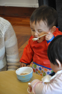 A boy using spoon to feed himself